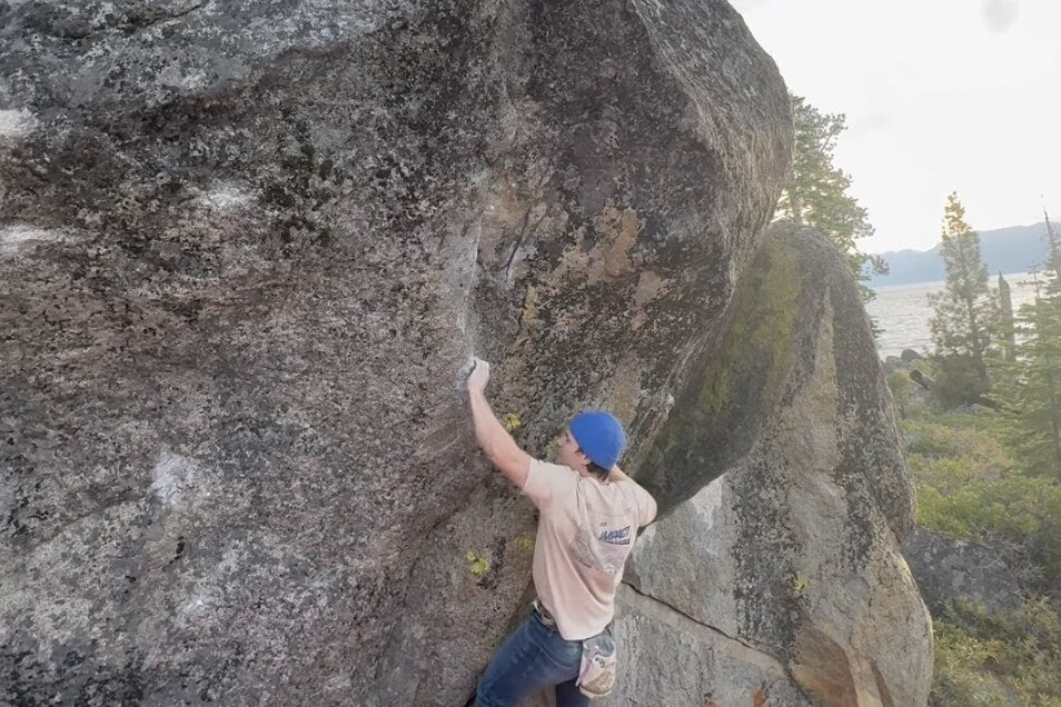 A climber on Zombie Kill Shot with Lake Tahoe behind, Glenbrook east shore