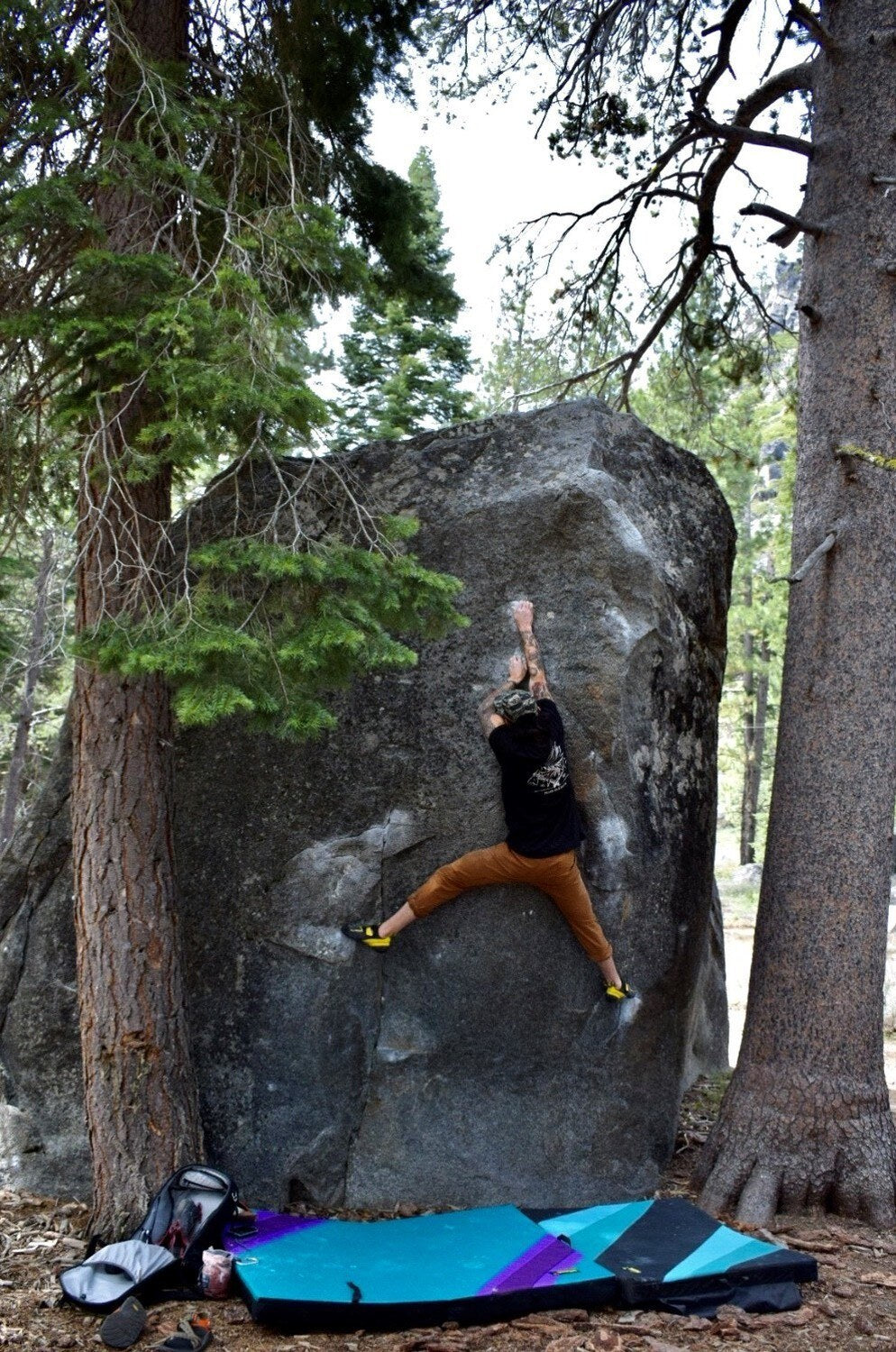A climber on a granite boulder in the pines at Christmas Valley, South Lake Tahoe
